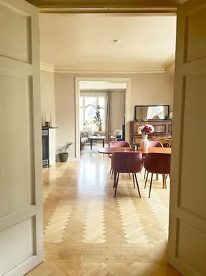 a living room with a table and chairs in it at Authenic Art Nouveau Apartment in the city-center in Ålesund