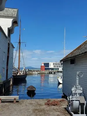 a boat is docked in the water next to a building at Authenic Art Nouveau Apartment in the city-center in Ålesund