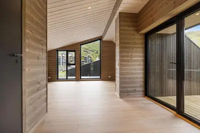 an open hallway with wooden walls and glass doors at Mountain View Apartment - penthouse in Stranda