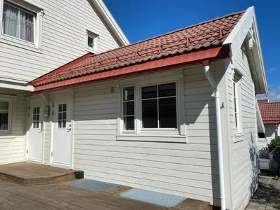a small white building with a red roof at Newly renovated studio apartment - free parking and EV docking in Trondheim