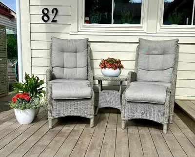 two wicker chairs and a table on a porch at Newly renovated studio apartment - free parking and EV docking in Trondheim