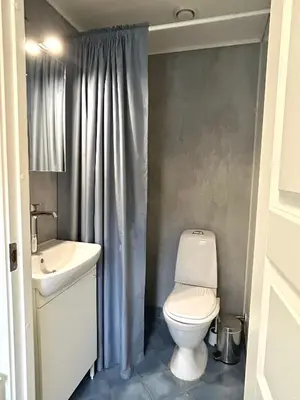 a bathroom with a toilet and a sink at Newly renovated studio apartment - free parking and EV docking in Trondheim
