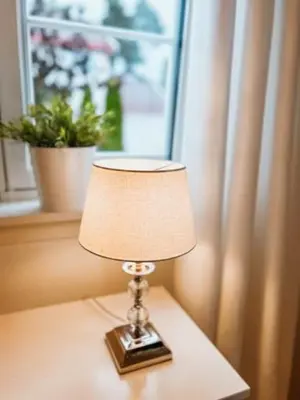a lamp sitting on a table in front of a window at Newly renovated studio apartment - free parking and EV docking in Trondheim