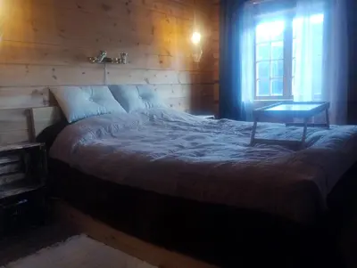 a bedroom with a bed with a table and a window at Langlete gjestehus in Gilset