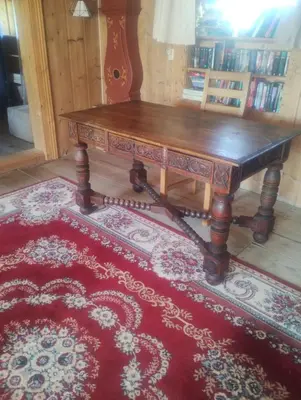 a wooden table sitting on top of a red rug at Langlete gjestehus in Gilset