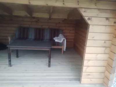 a wooden dog house with a bench in it at Langlete gjestehus in Gilset