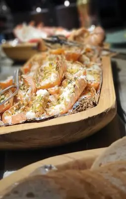 a wooden plate of pizza on a table with bread at Boathouse in Mausund in Bogøyvær