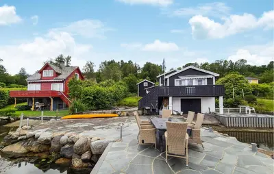 a house with a table and chairs next to a body of water at Stunning Home In Førde I Hordaland in Erve