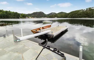 a boat on a dock on a lake at Stunning Home In Førde I Hordaland in Erve
