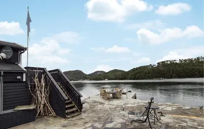 a dock with a table and chairs next to a body of water at Stunning Home In Førde I Hordaland in Erve