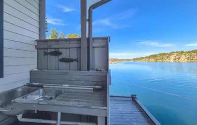 a bath tub sitting on a dock next to a body of water at Lovely Home In Urangsvåg in Steinsbø