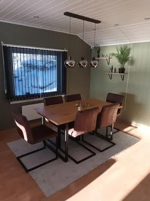 a dining room with a wooden table and chairs at Sentralt, kort vei til byens fasiliteter in Molde