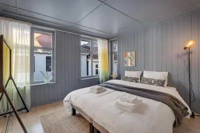 a bedroom with a large bed and two windows at The Townhouse Dream I Must See Views! in Bergen