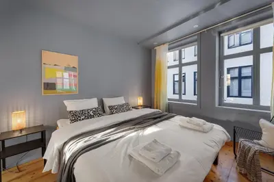 a bedroom with a large bed and two windows at The Townhouse Dream I Must See Views! in Bergen