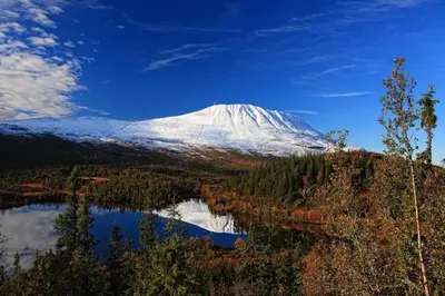 a snow covered mountain with a reflection in a lake at Lägenhet med utsikt mot Gaustatoppen, ski in ski out in Gaustablikk