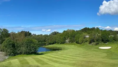 a golf course with a hole and a pond at Luxury apartment Bergen in Bergen