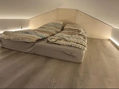 a bed with a blanket on the floor in a room at Luxury apartment Bergen in Bergen