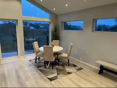a dining room with a table and chairs and windows at Luxury apartment Bergen in Bergen