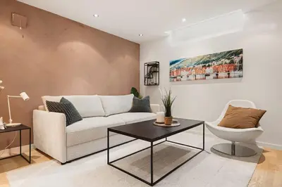 a living room with a couch and a table at Dinbnb Apartments I Cobblestone Streets 350m from Bryggen & Fløybanen! in Bergen