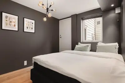 a bedroom with a large white bed and a window at Dinbnb Apartments I Cobblestone Streets 350m from Bryggen & Fløybanen! in Bergen