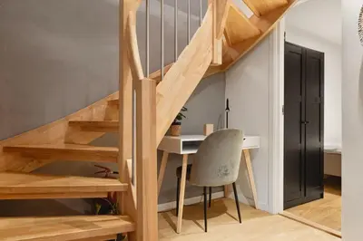a desk and a chair in a room with stairs at Dinbnb Apartments I Cobblestone Streets 350m from Bryggen & Fløybanen! in Bergen