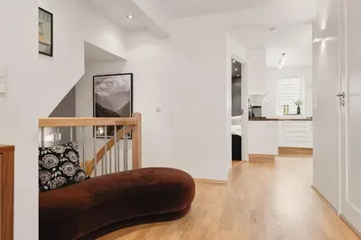 a living room with a brown ottoman on the floor at Dinbnb Apartments I Cobblestone Streets 350m from Bryggen & Fløybanen! in Bergen