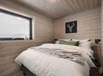 a bedroom with a large bed with a window at Flygende utsiktshytte med magisk utsikt in Sogndal