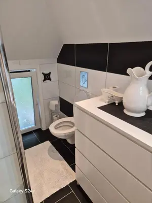 a bathroom with a toilet and a vase on a counter at APARTAMENT Duże mieszkanie W centrum Ålesund in Ålesund