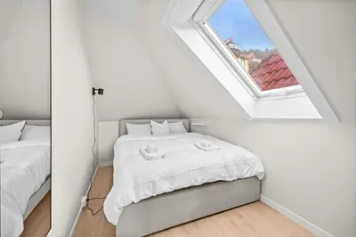 a white room with a bed and a window at View to Bryggen - Renovated dec 24 - Historic cobblestone street in Bergen