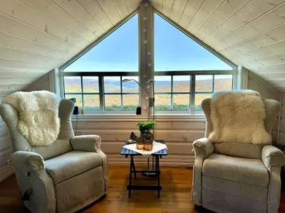 two chairs and a table in a room with a large window at Cozy Ski-In Ski-Out Apartment on Geilo, Stunning Views! in Geilo