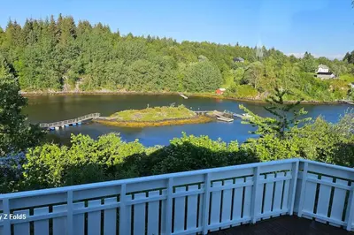 a view of a river from a balcony at Koselig hytte på Austrheim