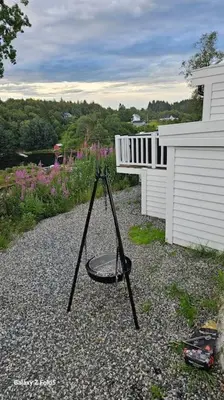 a swing on the gravel next to a building at Koselig hytte på Austrheim