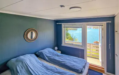 a blue bedroom with a bed and a window at 4 Bedroom Awesome Home In Ølve in Ølve