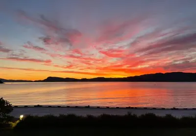 a sunset over a large body of water at seaside house with stunning sunsets & sun all day Near Trondheim in Buvika