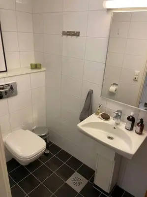 a white bathroom with a toilet and a sink at seaside house with stunning sunsets & sun all day Near Trondheim in Buvika