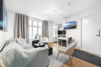 a living room with a couch and a tv at Homerentals Apartments - Behind Bryggen & historic cobblestone streets - 2 Floor renovated from february 2025 in Bergen
