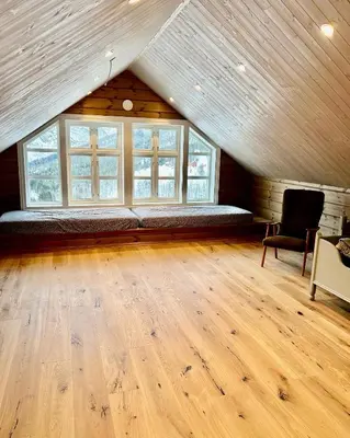 a large room with a bed in a attic at Jostedal Lodge in Jostedal