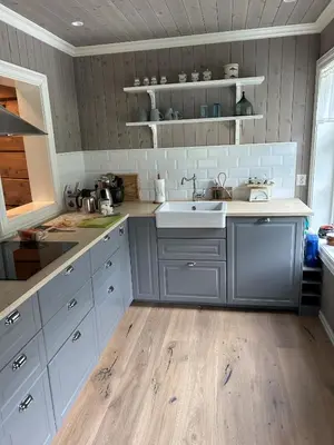 a kitchen with white cabinets and a sink at Jostedal Lodge in Jostedal
