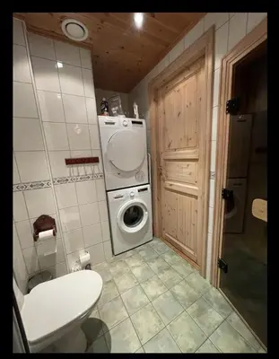 a bathroom with a washing machine and a washer at Storsten 725C in Trysil
