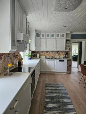 a kitchen with white cabinets and a rug at Familie og gruppevennlig hus 12 senger 240kvm in Oppdal