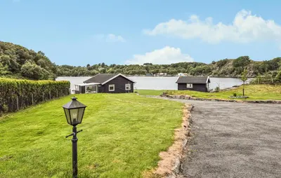 a street light in the grass next to a house at Amazing Home In Haugesund in Haugesund