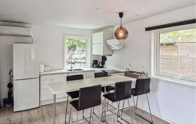 a white kitchen with a table and chairs at Amazing Home In Haugesund in Haugesund
