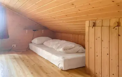 a bed in a room with a wooden ceiling at Stunning Home In Lauvstad With House Sea View in Lauvstad