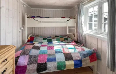 a small bedroom with a bed with a colorful quilt at 3 Bedroom Lovely Home In Sjusjøen in Sjusjøen