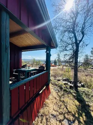 a porch of a building with a table and chairs at Nydelig naturperle på Nesbyen, nær Langedrag in Nesbyen
