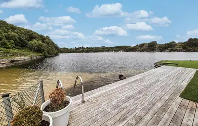 a man sitting on a dock in the water at 2 Bedroom Lovely Home In Haugesund in Haugesund