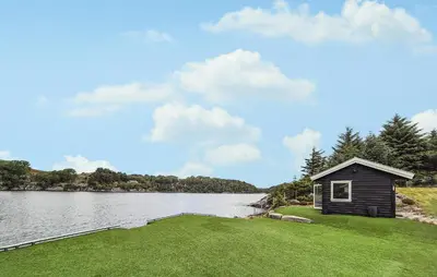 a small cabin on the side of a lake at 2 Bedroom Lovely Home In Haugesund in Haugesund