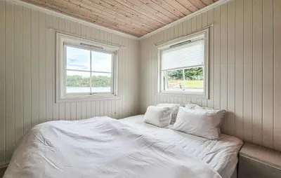 a white bed in a room with two windows at 2 Bedroom Lovely Home In Haugesund in Haugesund
