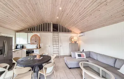 a kitchen and a living room with a table and a couch at 2 Bedroom Lovely Home In Haugesund in Haugesund