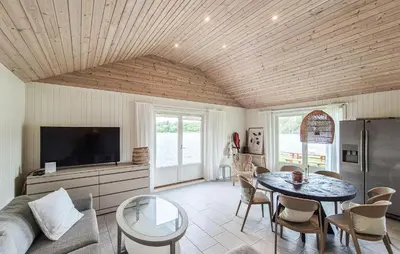 a living room with a table and a tv at 2 Bedroom Lovely Home In Haugesund in Haugesund